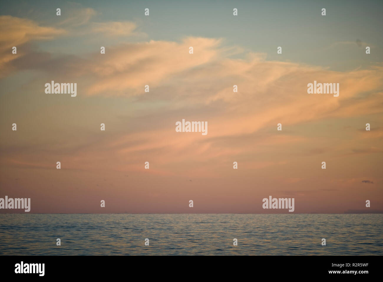 Nuvole nel cielo sopra l'oceano al tramonto. Foto Stock