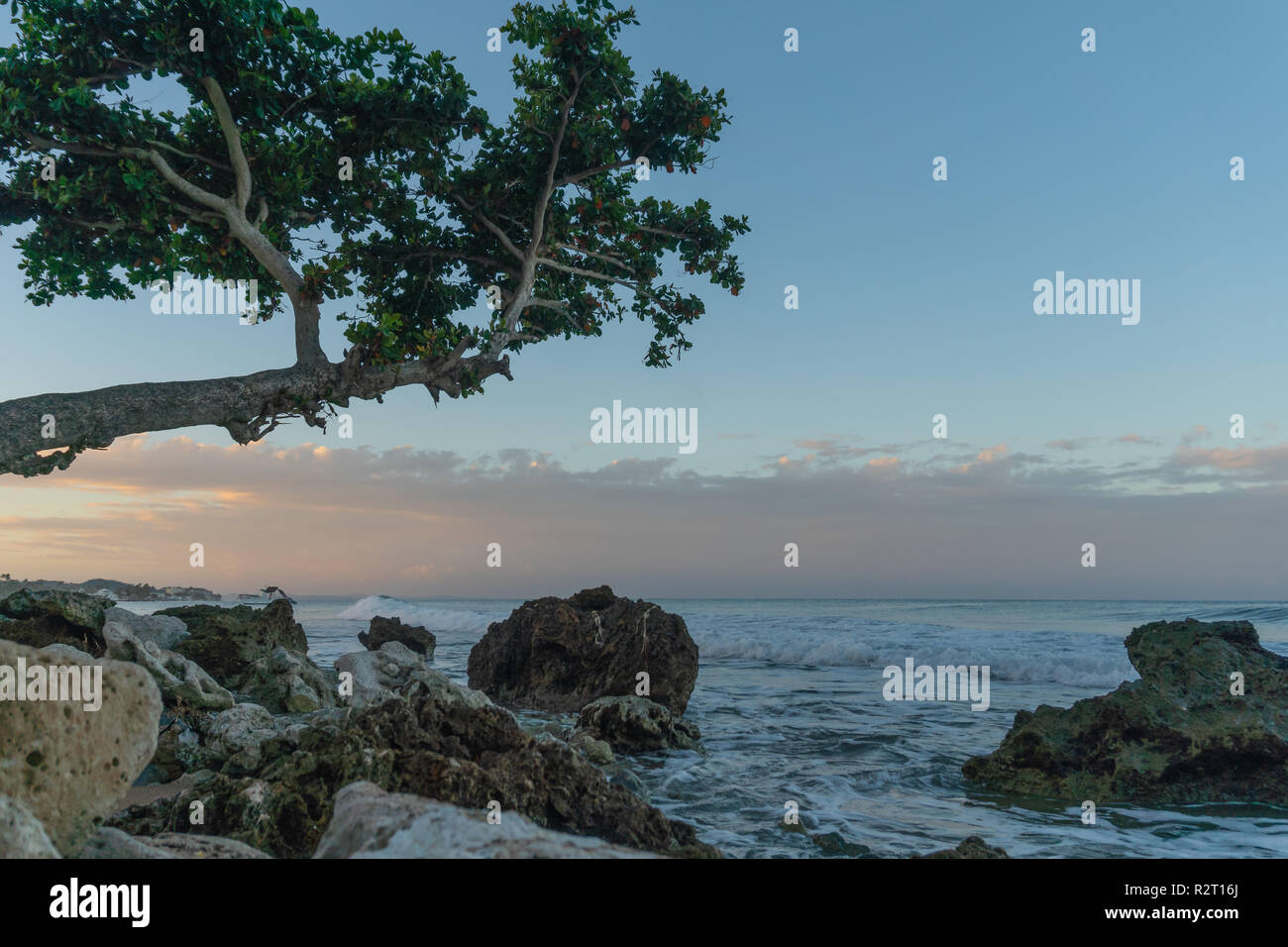 Osservare il tramonto sulla costa di Rincon, Puerto Rico come arrivano le onde durante il sunrise. Foto Stock