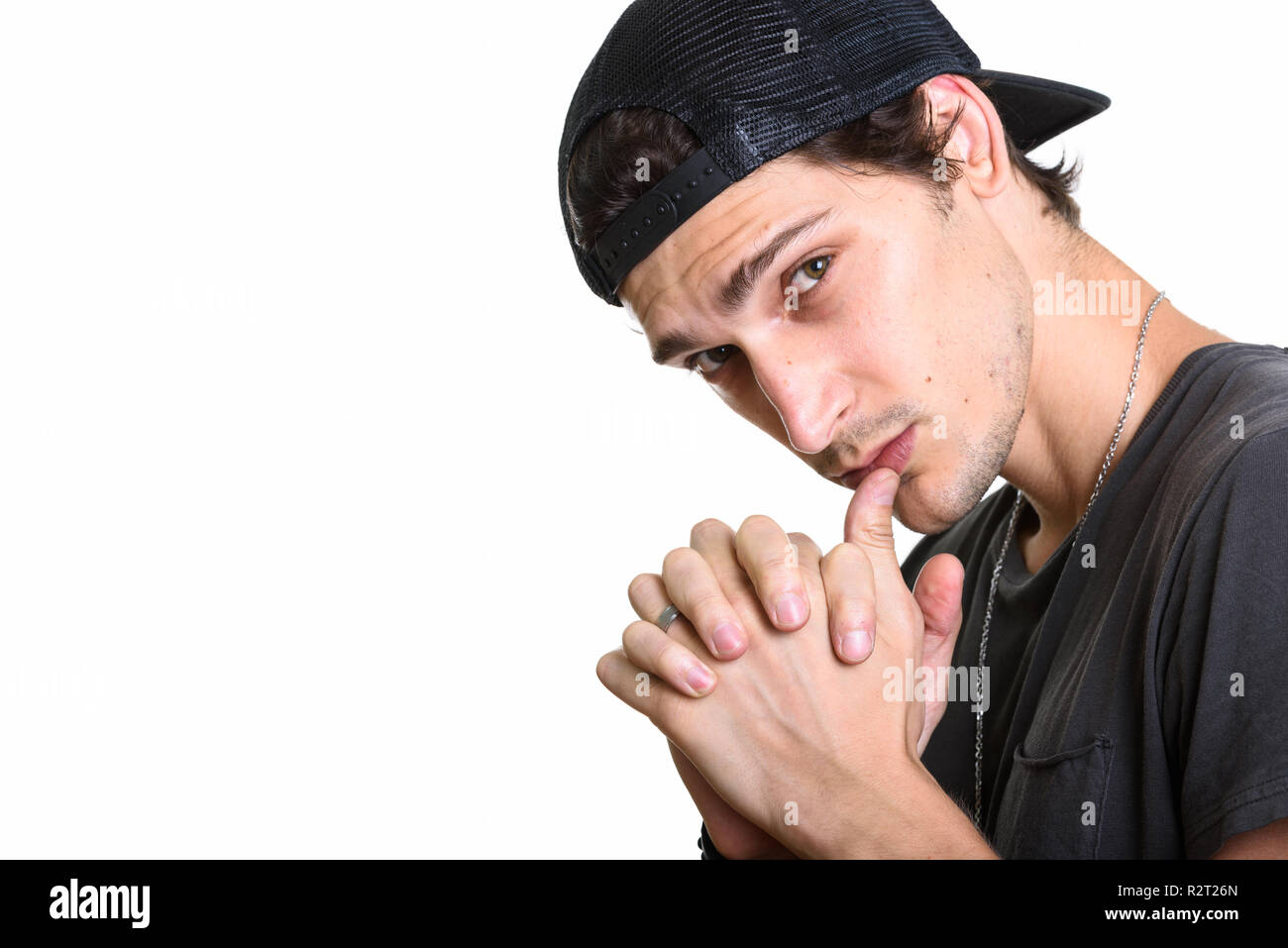 Chiusura del giovane uomo bello indossare snapback durante intertwini Foto Stock