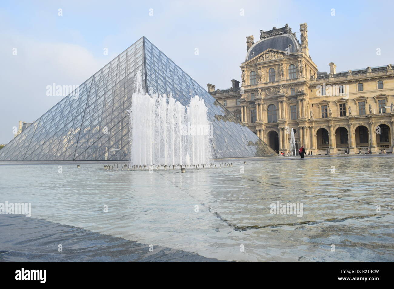 La piramide di vetro e una fontana nel cortile del Palais du Louvre, Parigi, Francia Foto Stock