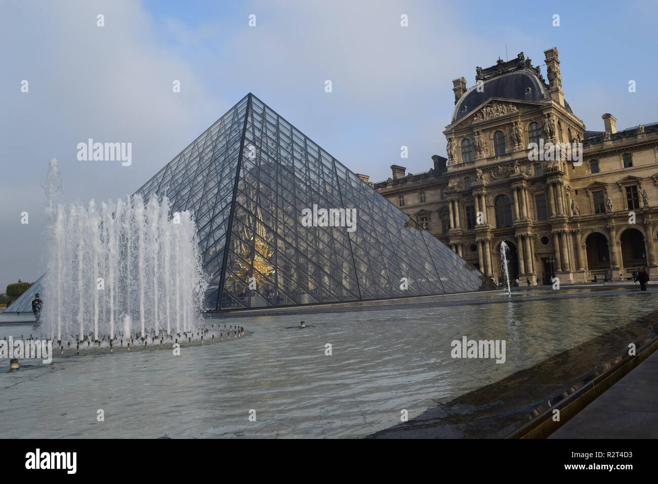 La piramide di vetro e una fontana nel cortile del Palais du Louvre, Parigi, Francia Foto Stock