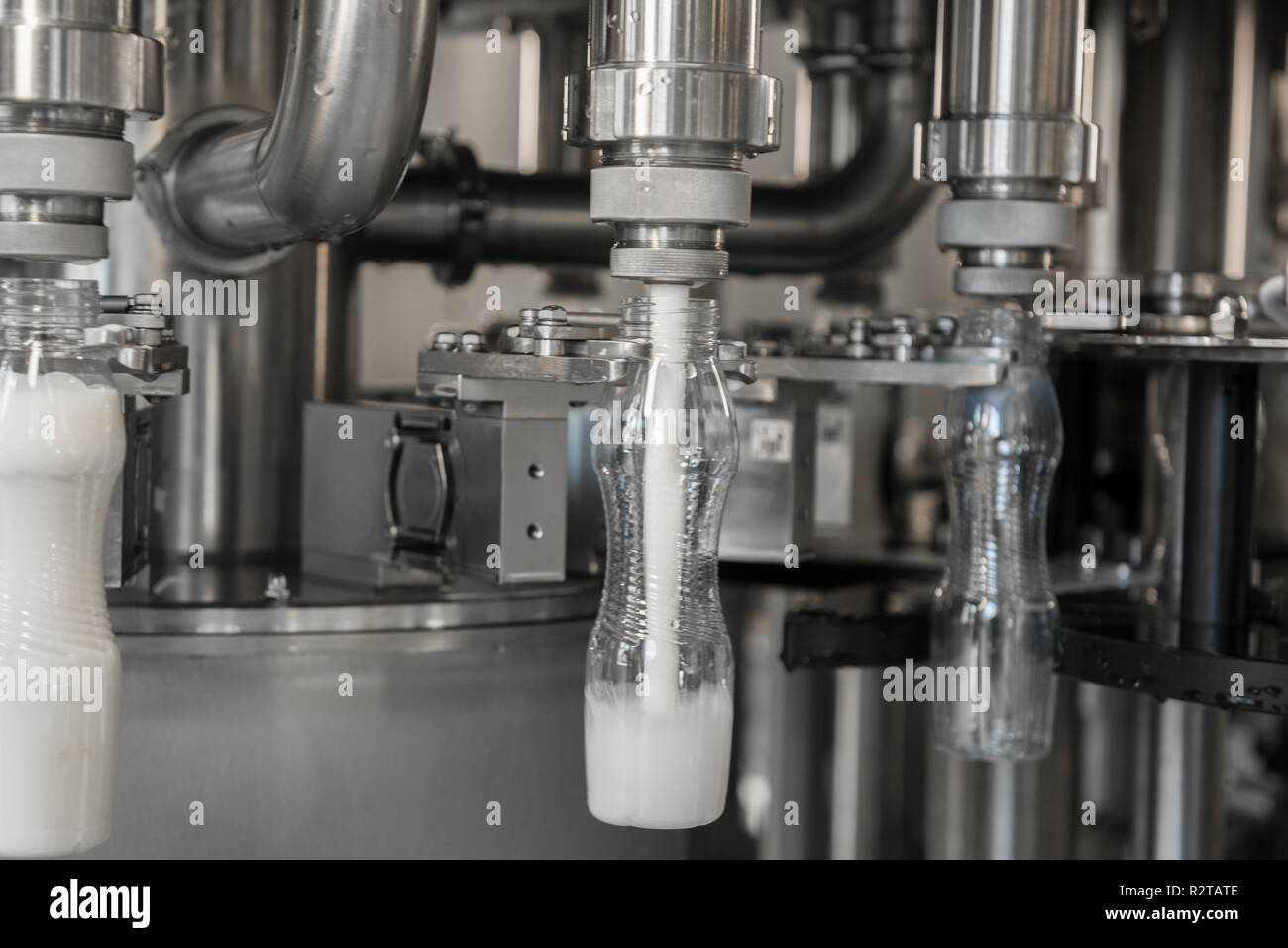 Il riempimento di latte in bottiglie di plastica in fabbrica. apparecchiature presso il caseificio Foto Stock