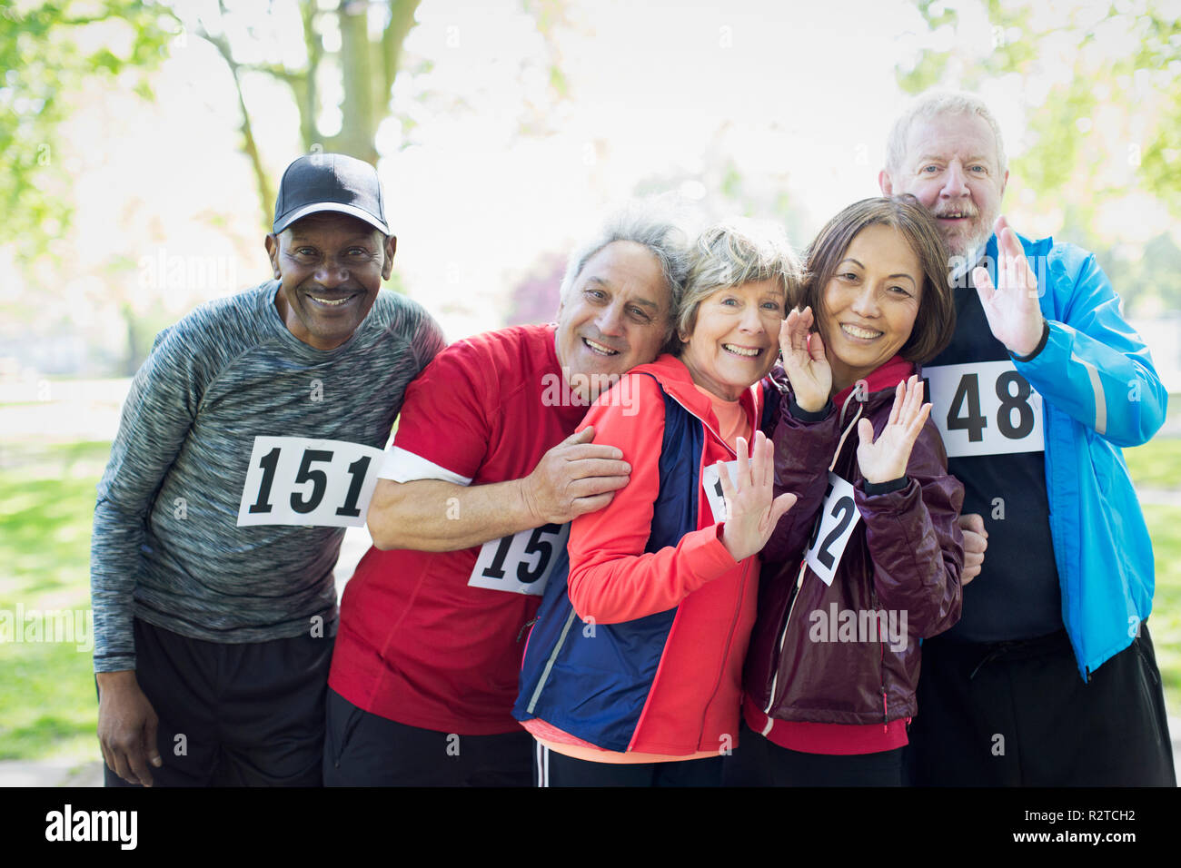 Ritratto fiducioso active senior runner amici indossando gara sportiva bibs Foto Stock