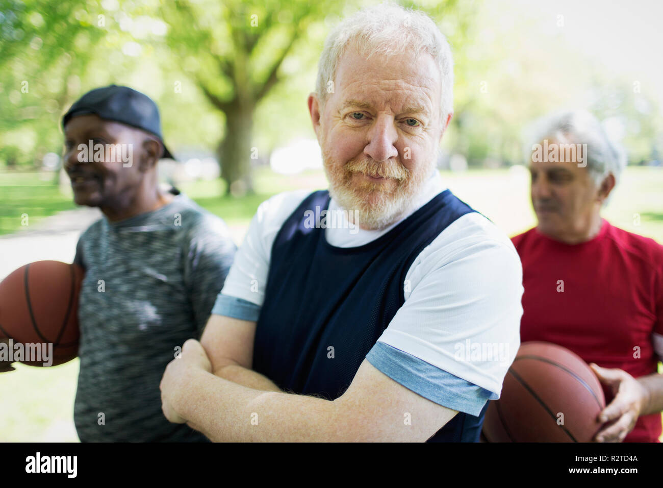 Ritratto fiducioso attivo uomo senior di giocare a basket con gli amici Foto Stock
