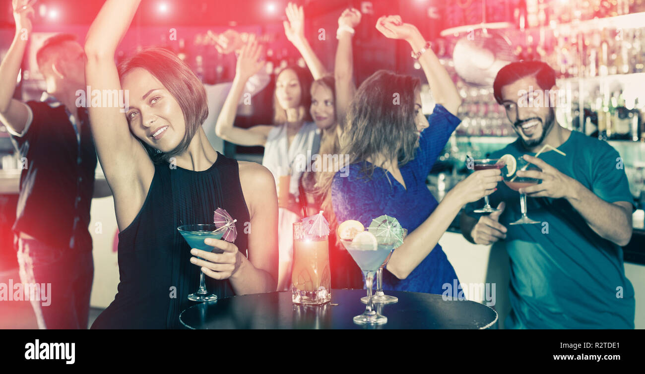 Femmina è ballare e bere un cocktail sulla parte in bar. Foto Stock