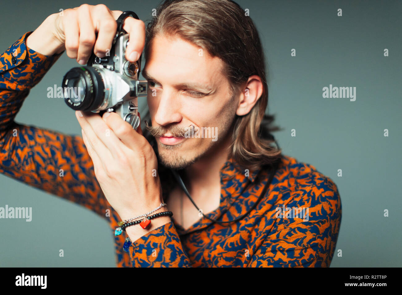 Giovane uomo con i baffi manubrio utilizzando fotocamera retrò Foto Stock