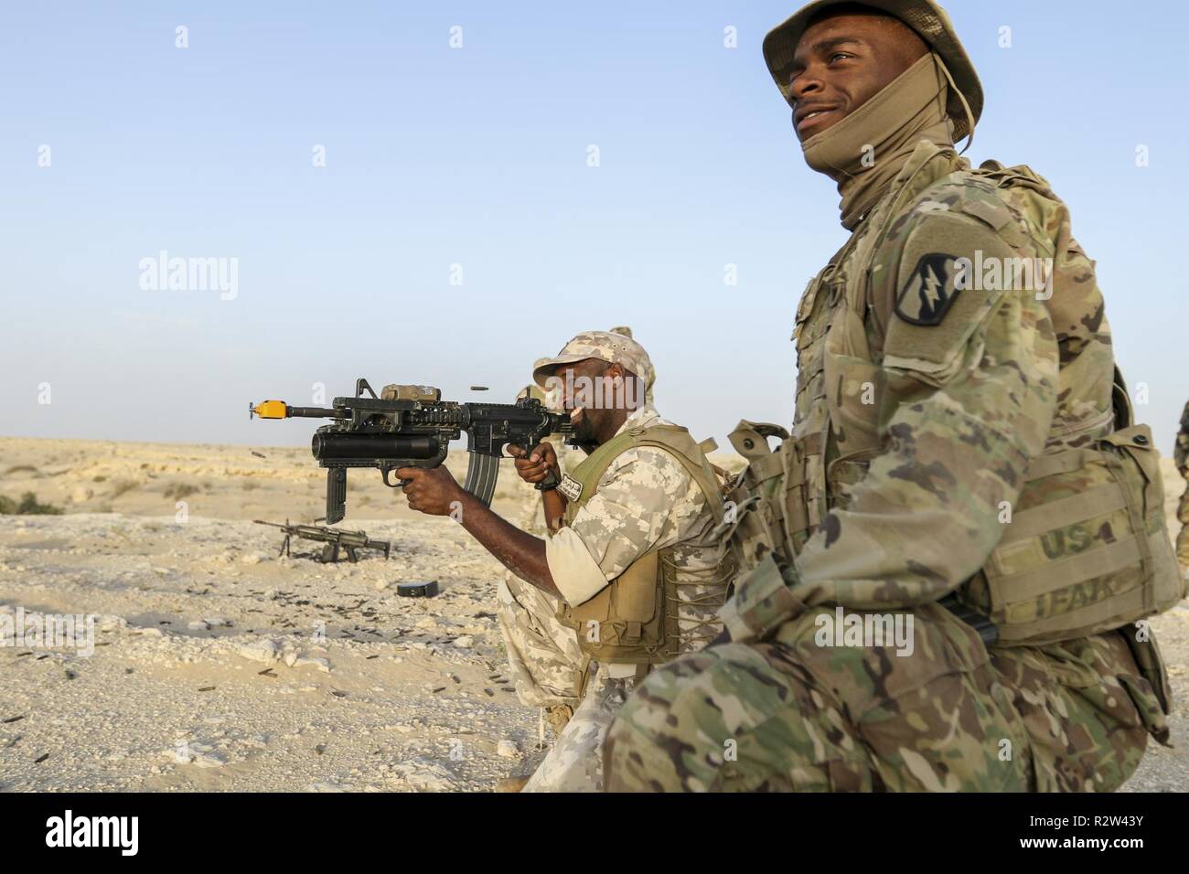 UM HATTAH, Qatar - STATI UNITI Army Spc. Jason Adams, un fante assegnati al 2° Battaglione, 198th Armor reggimento, 155Armored Brigade Combat Team, Task Force Spartan, funziona con un soldato Qatar durante il bunker di formazione di compensazione come parte di esercitare azione orientale 19 nov. 7, 2018. Azione orientale, un bi-esercizio laterale tra gli Stati Uniti e il Qatar, combina le due forze attraverso una serie di eventi di formazione come Malta, cecchino di fanteria, e più. Foto Stock