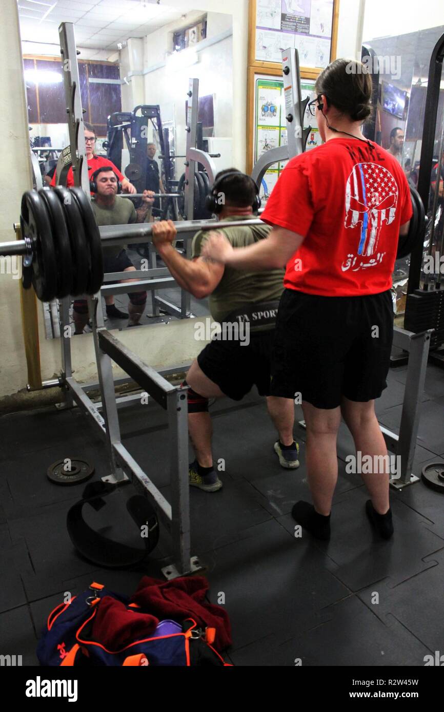 Cpl. Victoria di lepre Coffeyville, Oklahoma guarda attentamente come Staff Sgt. Roberto Manzo di Stewart Florida inizia un altro deadlift ripetizione a Camp Taji. Entrambi i soldati sono da 321il supporto dei vigili del fuoco e tenere premuto il tasto di accensione il sollevamento di record in più eventi presso il camp. Foto Stock