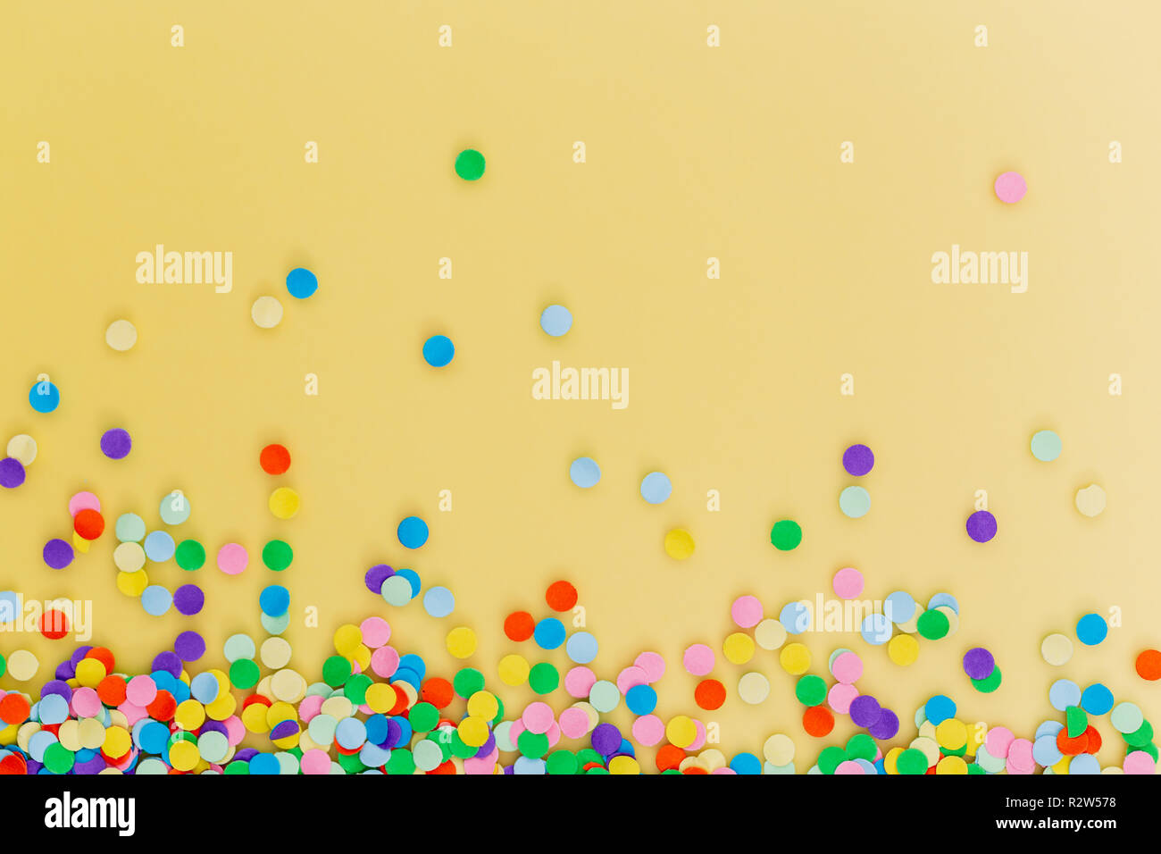 Coriandoli colorati su sfondo giallo. Foto Stock