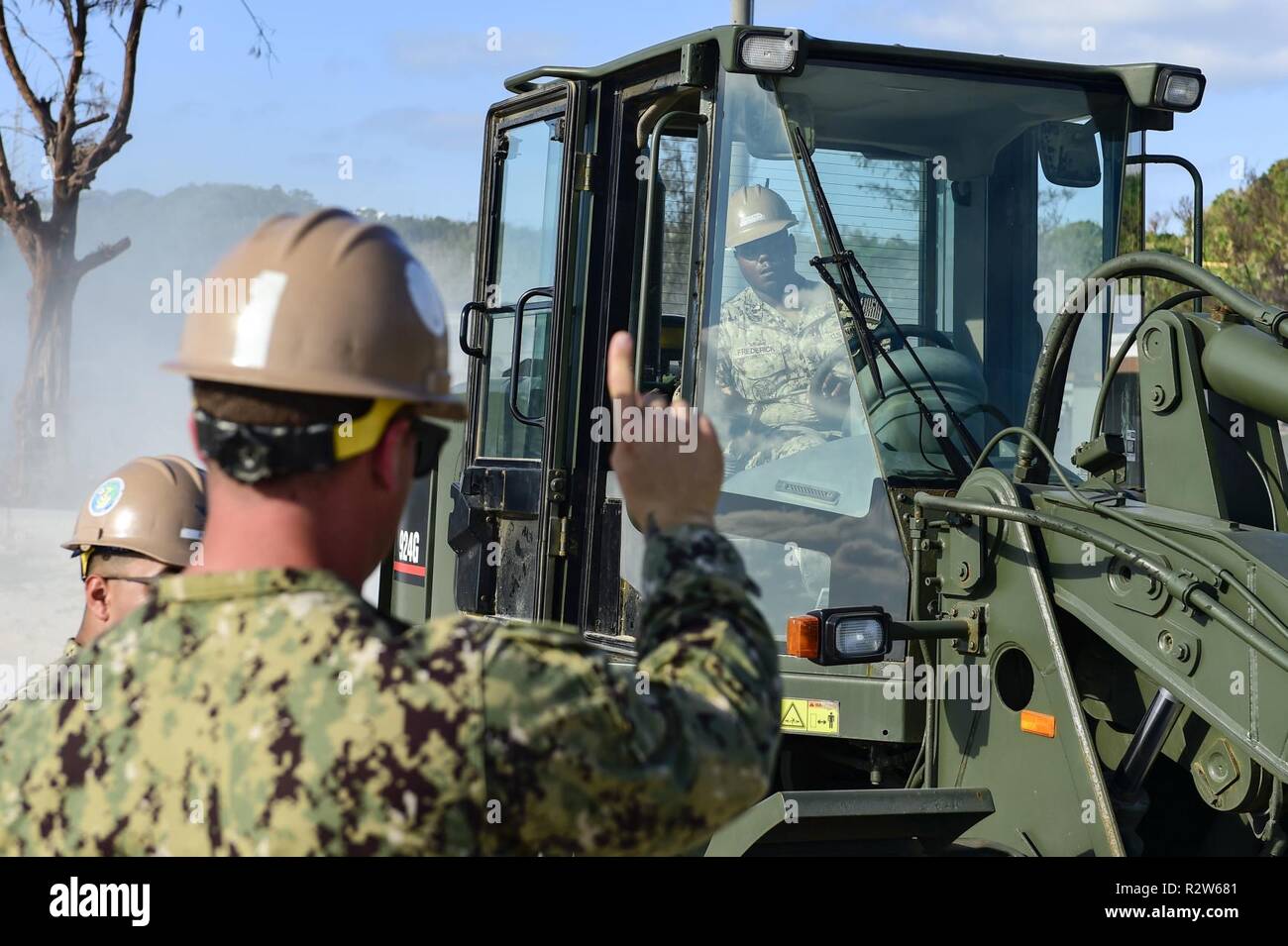 OKINAWA, in Giappone (nov. 8, 2018) Operatore di apparecchiature di seconda classe Christopher Manero, guide operatore di apparecchiature di terza classe Fredereck Alvis, entrambi assegnati alla Naval Mobile Battaglione di costruzione (NMCB) 3, come egli utilizza un caricatore anteriore con spazzatrice allegato per rimuovere sabbia spostato da un percorso che è stato reso inutilizzabile a bordo spiaggia bianca Naval Facility a Okinawa, Giappone, come risultato di un recente tifone che ha avuto ripercussioni sull'isola. NMCB-3 è distribuito in tutto l'Indo-Pacifico regione e Stati Uniti pronto a sostenere importanti operazioni di combattimento, teatro sicurezza, assistenza umanitaria e disas Foto Stock