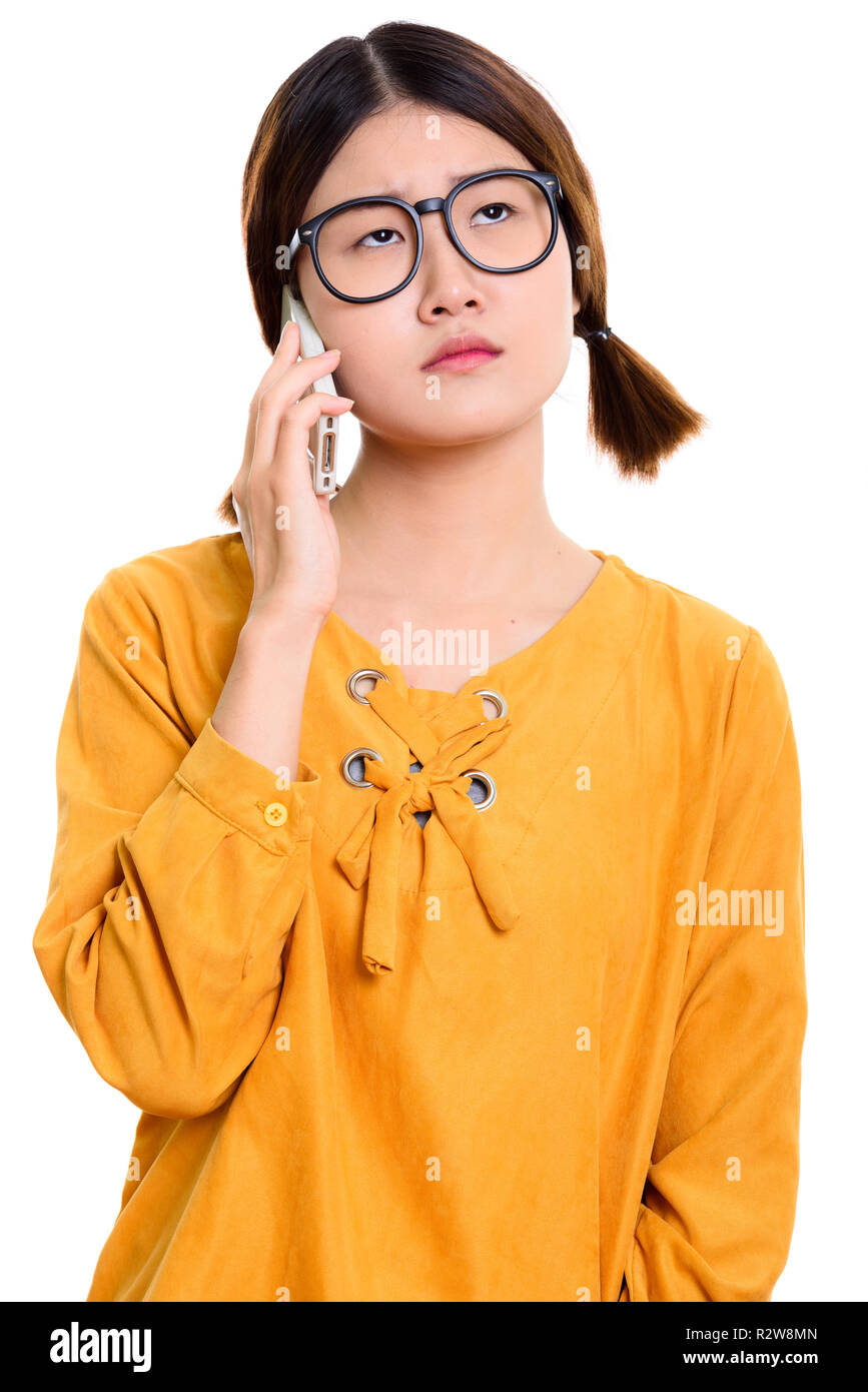 Giovani annoiati donna asiatica parlando al telefono cellulare Foto Stock