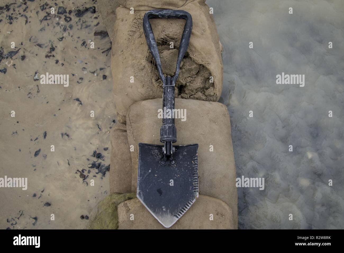 Un consolidamento utensile appoggia su un contrappeso barriera costruita per deviare le acque di esondazione dopo una pioggia torrenziale a Camp Arifjan, Kuwait, 15 novembre 2018. L allagamento è venuto dopo un insolitamente pesante acquazzone ha colpito la zona, che ha già avuto un notevole pioggia questo mese. Foto Stock