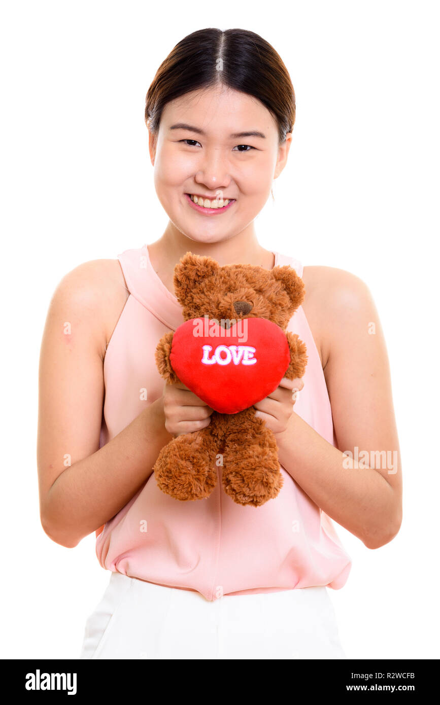 Studio shot di giovani felici donna asiatica sorridente e holding teddy Foto Stock