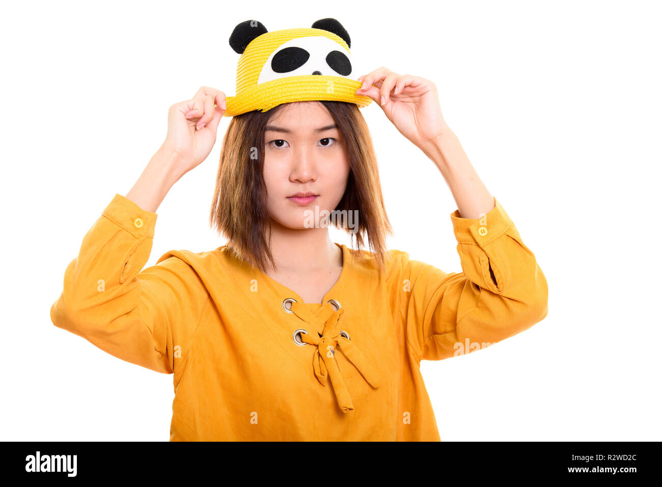 Studio shot del giovane bella donna asiatica holding hat con entrambi Foto Stock