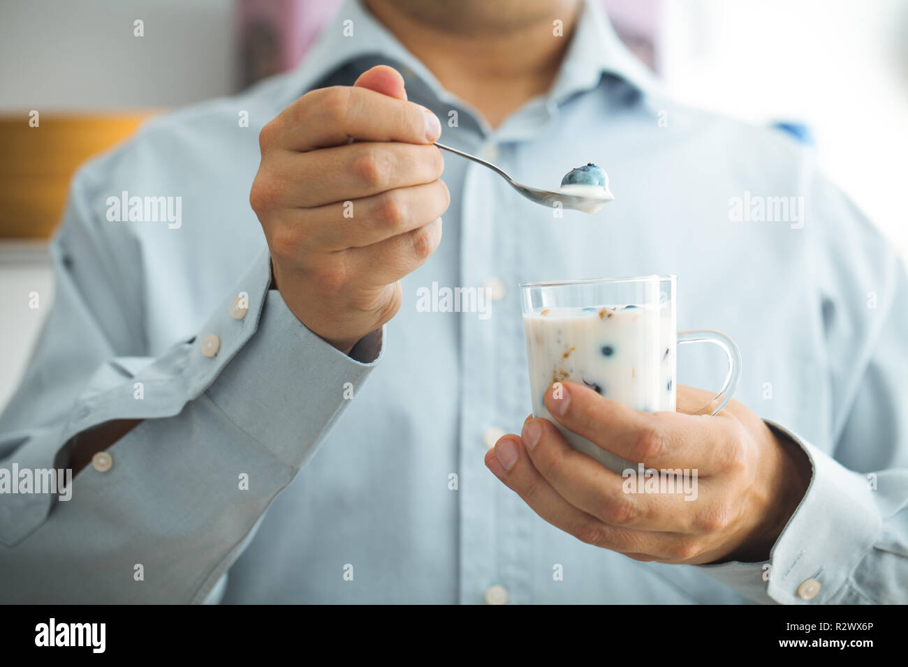 Colazione sana varietà. Yogurt con frutta e semi. Uomo con prima colazione Foto Stock