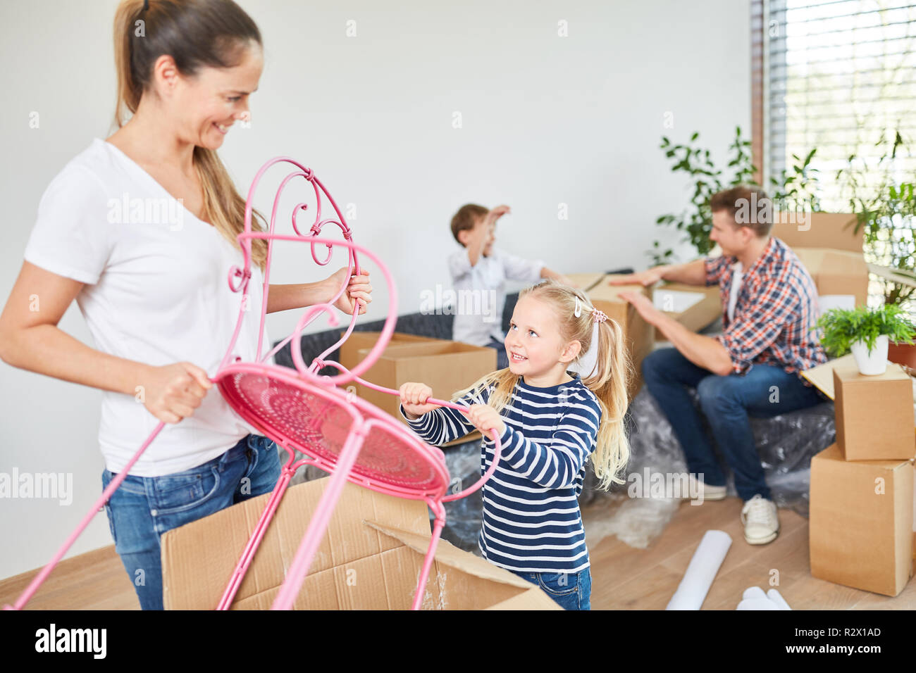 Figlia di madre aiuta il disimballaggio mobili nel nuovo appartamento Foto Stock