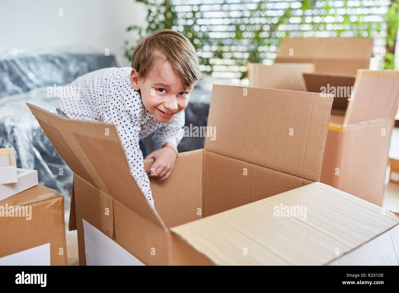 Giovani aiuta a spostare nella nuova casa e estrae una scatola di movimentazione Foto Stock