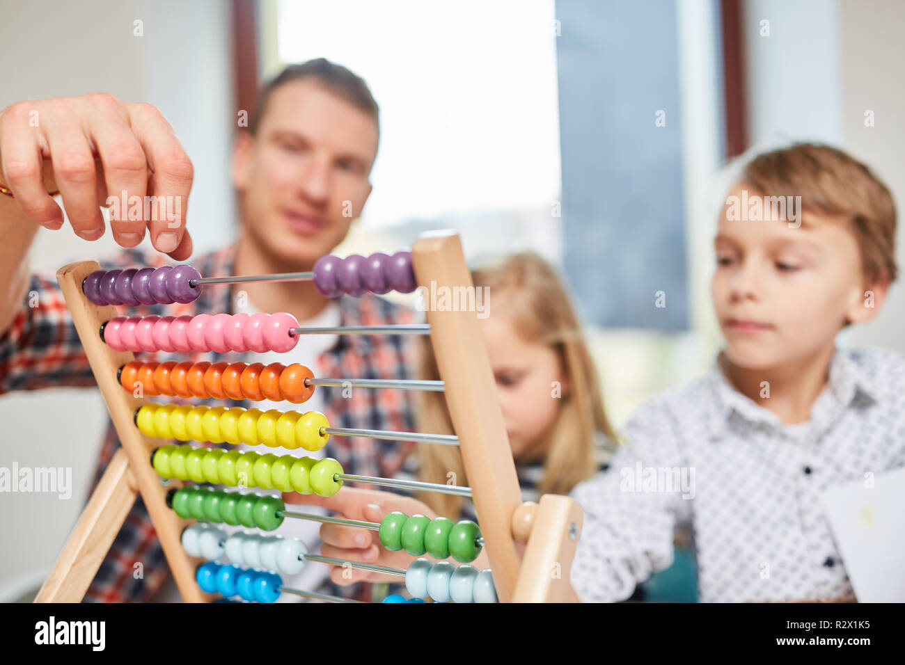 Padre e figli di calcolare i costi di costruzione di una casa e in movimento con abacus Foto Stock