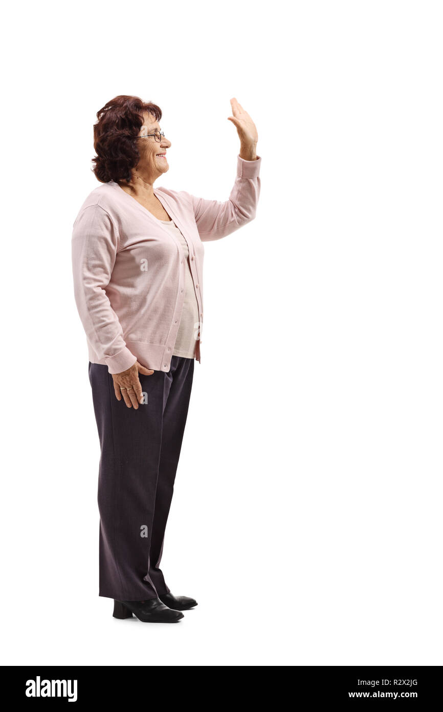 Lunghezza piena ripresa di profilo di un senior donna gesticolando alta cinque isolati su sfondo bianco Foto Stock
