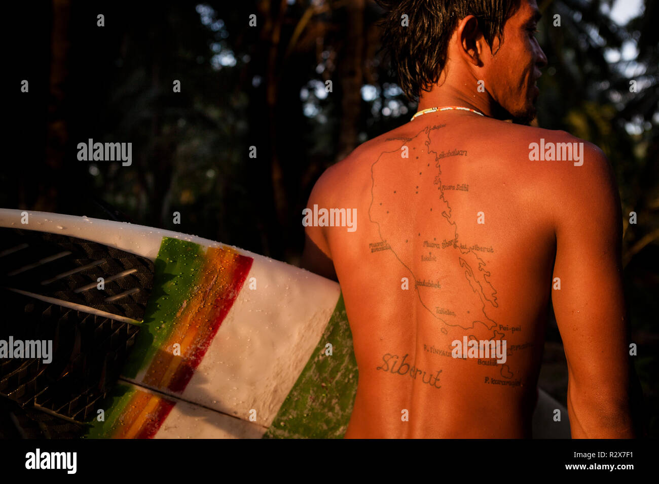 Guida Surf Ibrahim visualizzando un tatuaggio la mappatura di casa sua isola di Siberut, nelle Isole Mentawi. Foto Stock