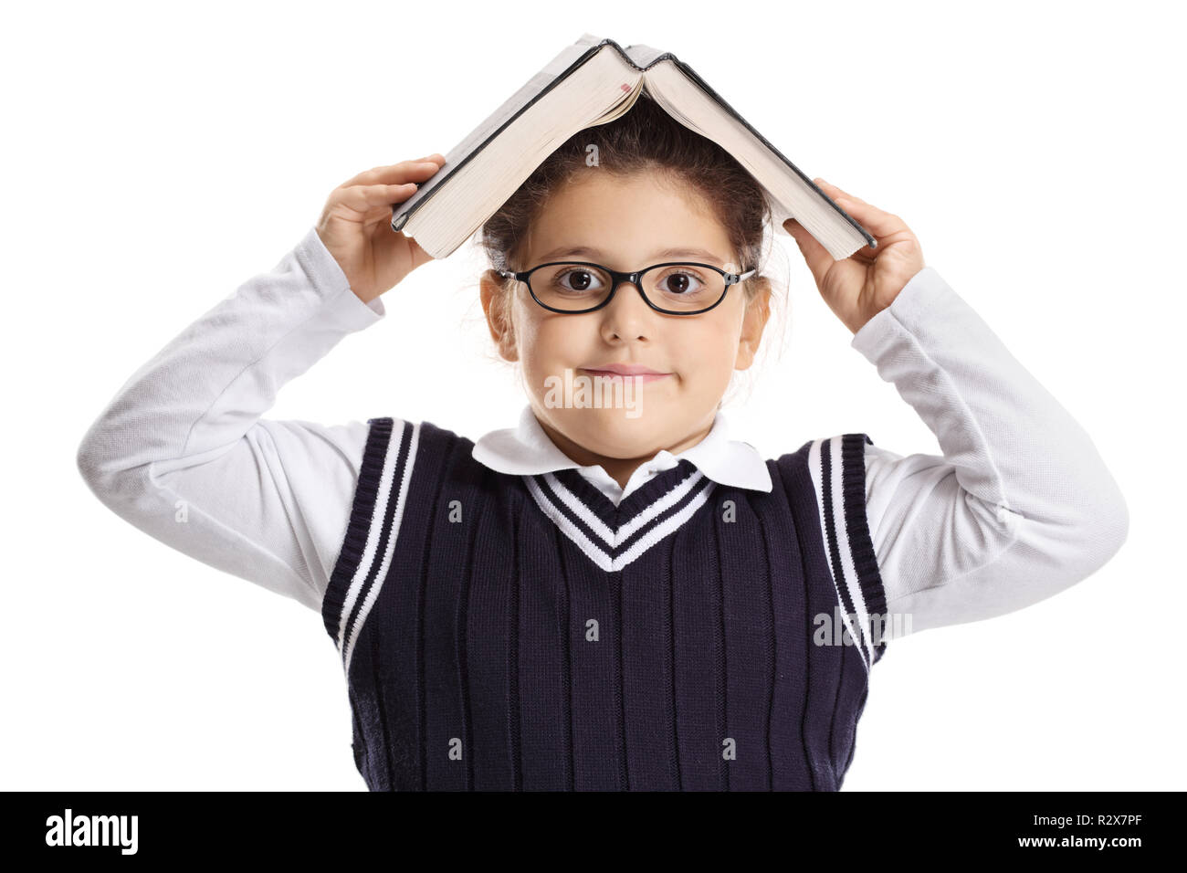 Little Schoolgirl tenendo un libro sopra la sua testa isolata su sfondo bianco Foto Stock