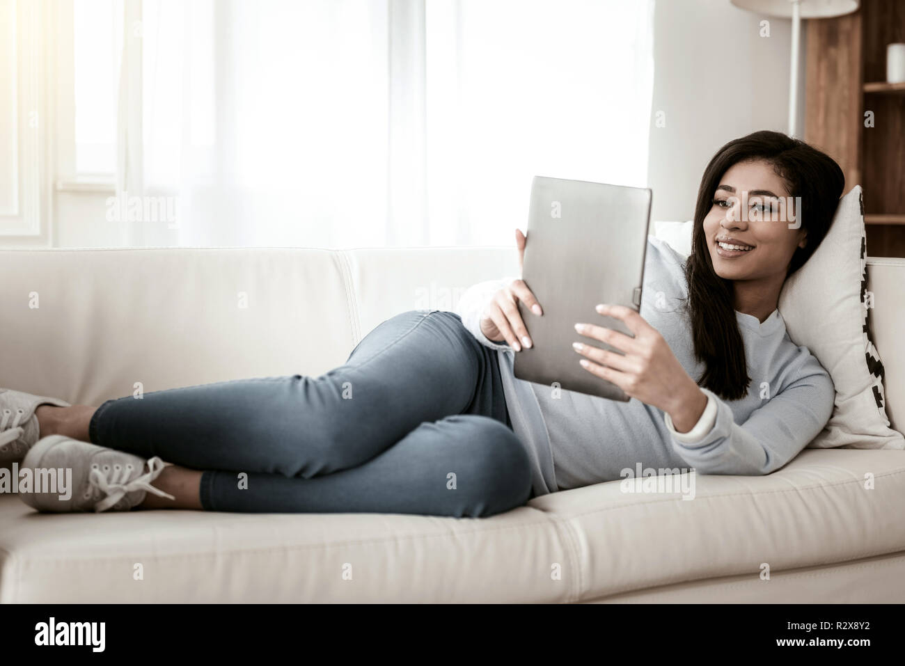 Piacere positivo internazionale femminile staring al tablet Foto Stock