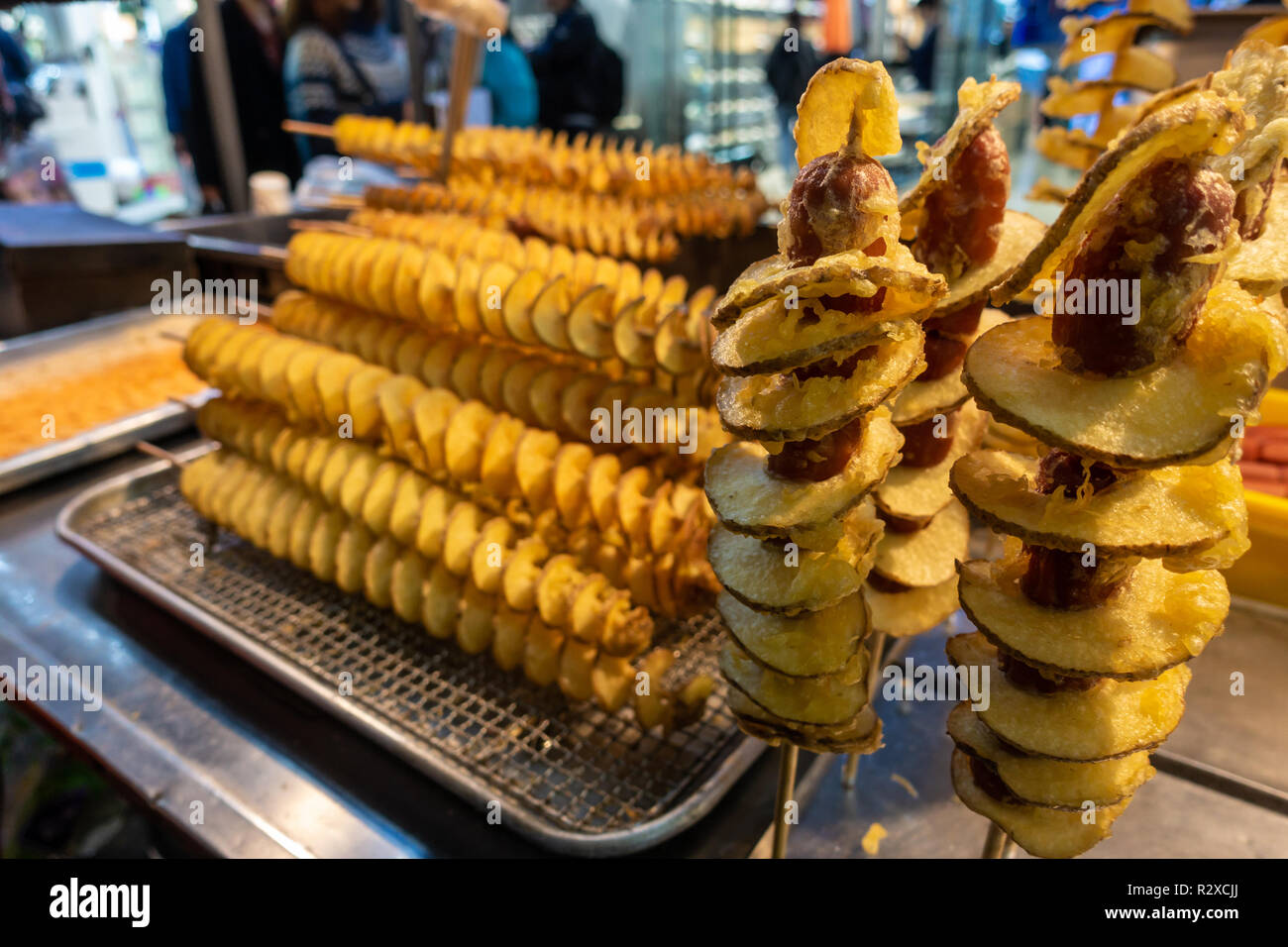 Un cibo di strada in stallo a Myeongdong a Seul, in Corea del Sud la vendita di fritte spirali di patate su legno scewers. Foto Stock