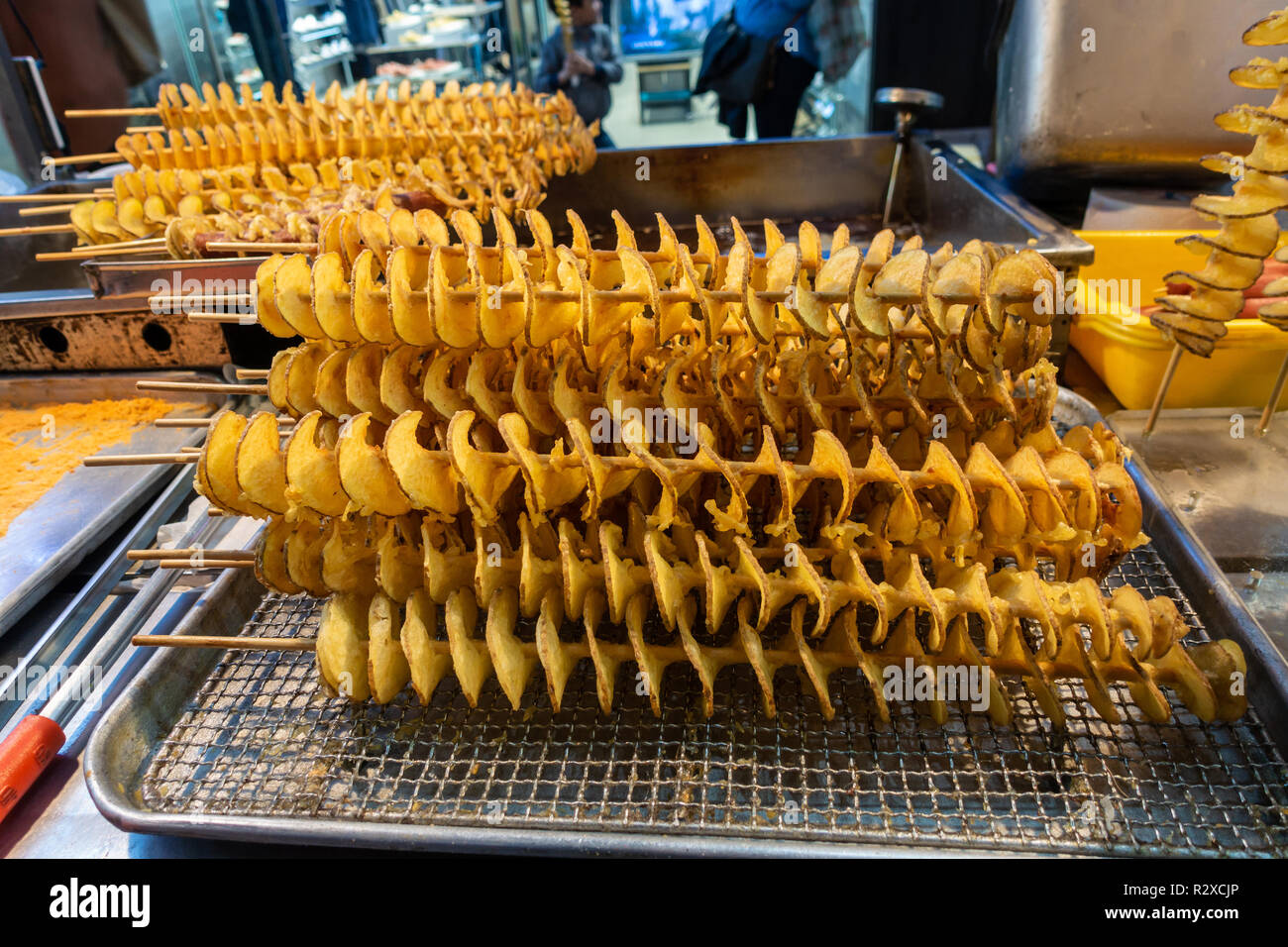 Un cibo di strada in stallo a Myeongdong a Seul, in Corea del Sud la vendita di fritte spirali di patate su legno scewers. Foto Stock