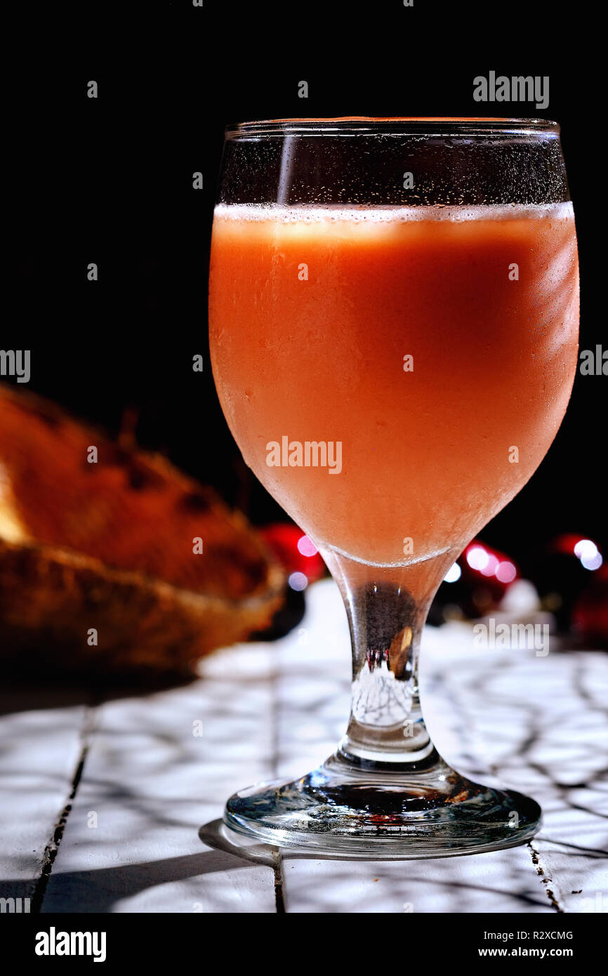 Gustoso il latte di cocco e il Berry smoothie nel vetro, ombre, con sfondo nero Foto Stock