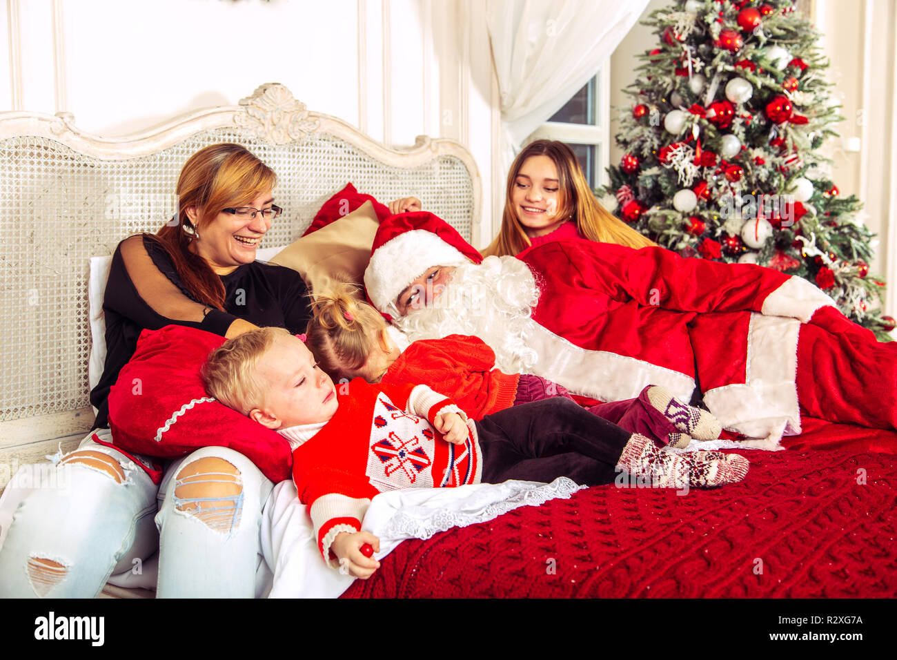 Natale ritratto di famiglia in camera da letto con un vero Babbo Natale.  L'atmosfera di festa e di divertimento Foto stock - Alamy