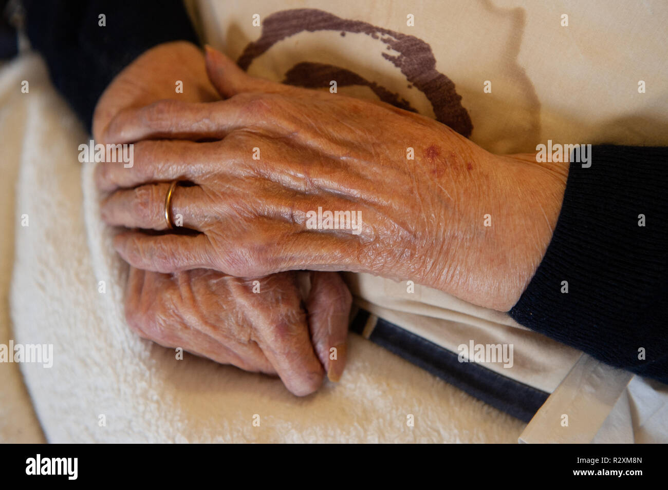 Vecchia Signora con le mani in mano che mostra l'età e l'oro wedding band. Foto Stock