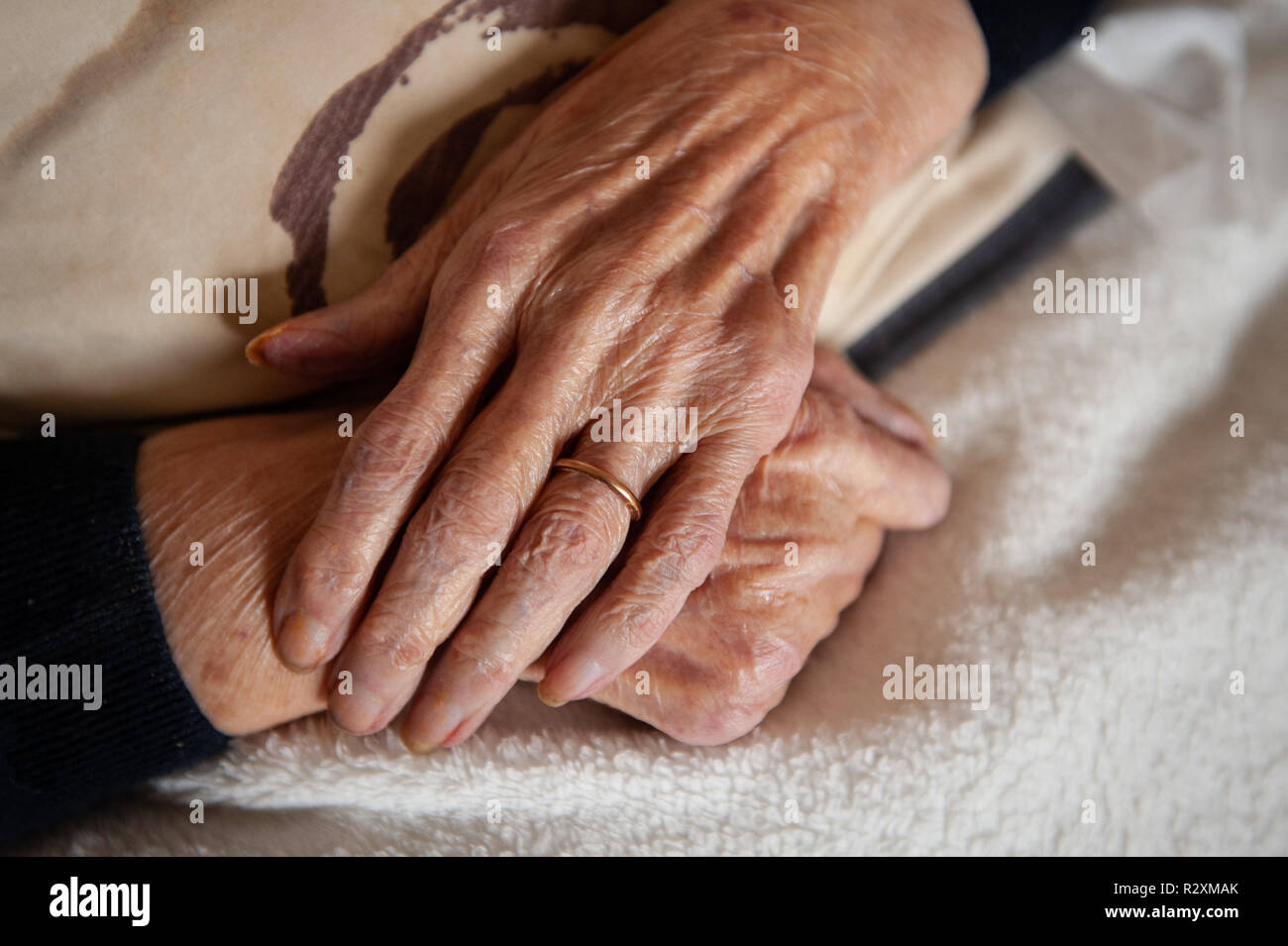 Vecchia Signora con le mani in mano che mostra l'età e l'oro wedding band. Foto Stock