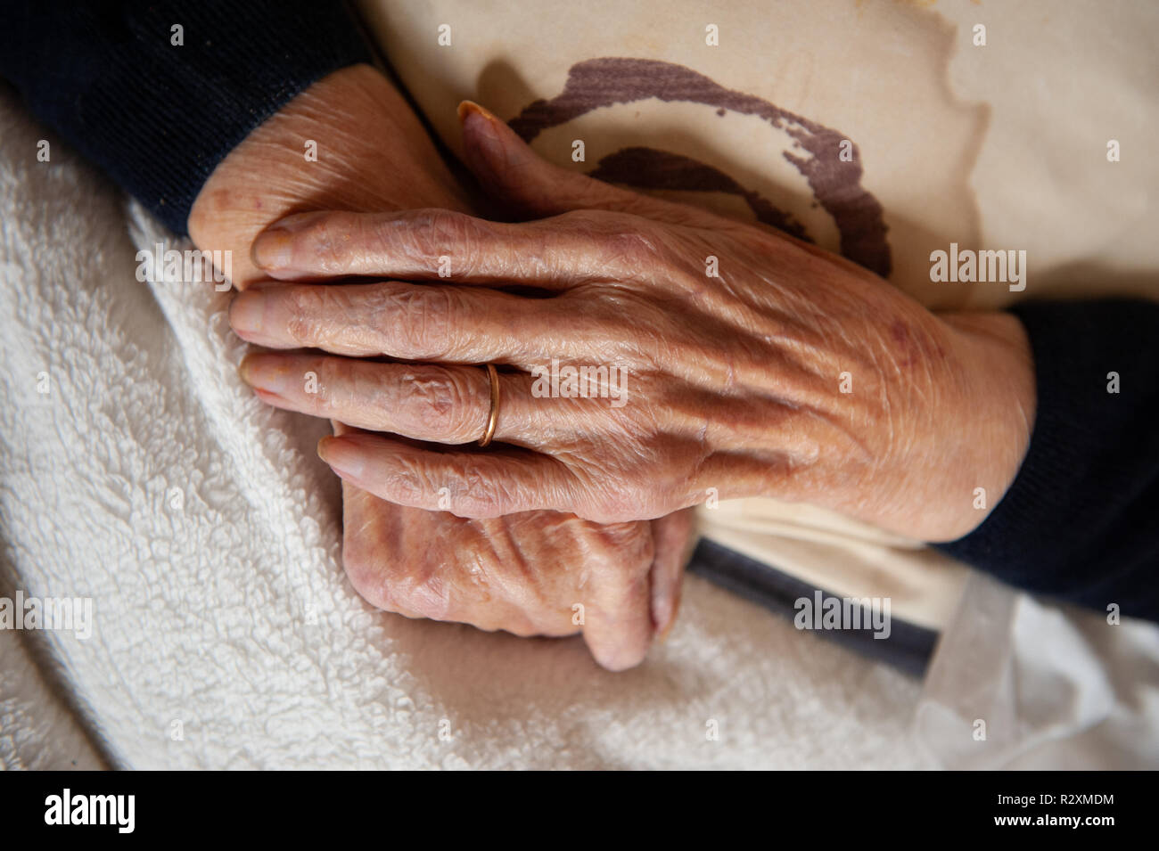 Vecchia Signora con le mani in mano che mostra l'età e l'oro wedding band. Foto Stock