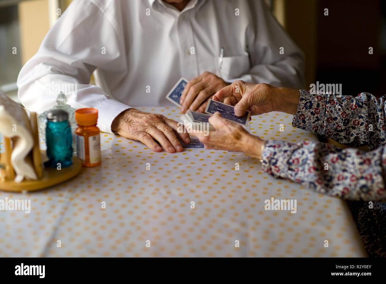 Coppia di anziani godono di carte da gioco insieme al tavolo della cucina. Foto Stock
