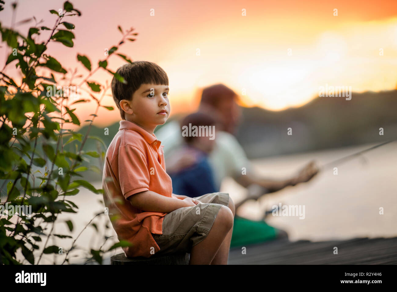 Padre e figli la pesca da un molo. Foto Stock