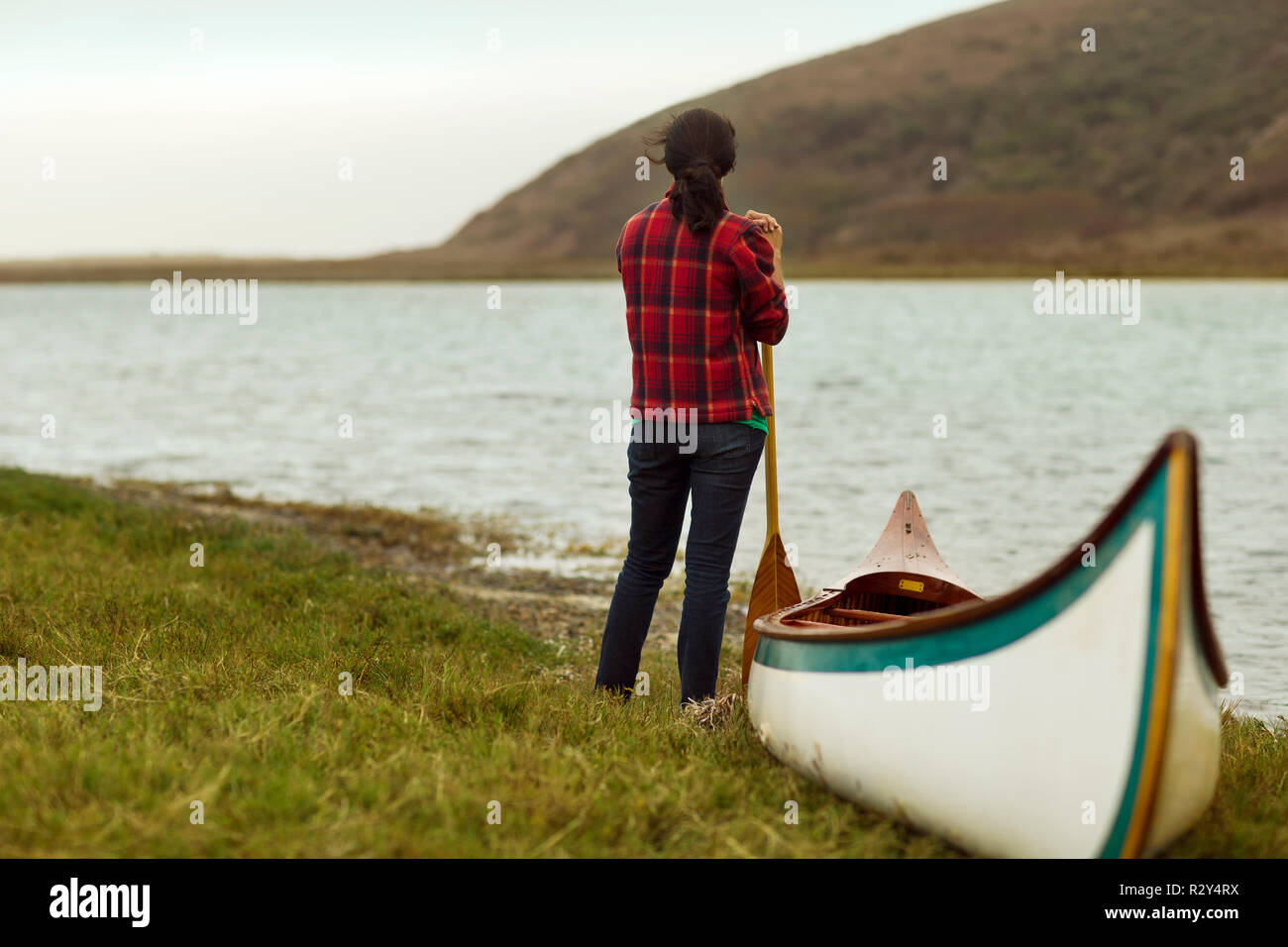 La donna si affaccia a a vista lago prima di canottaggio. Foto Stock