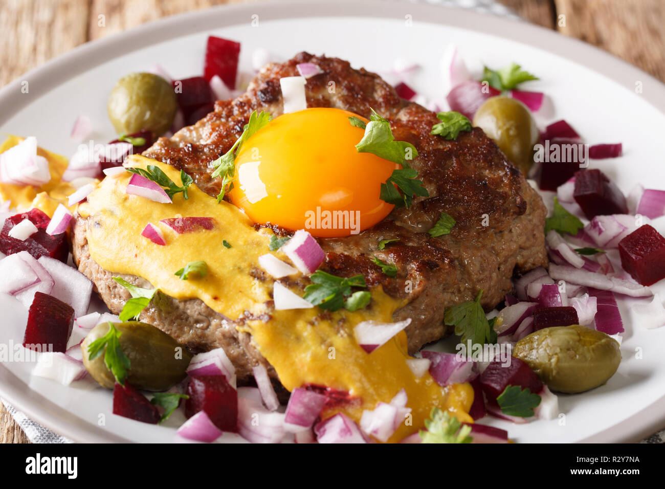 Pariserbof è una polpetta di carne di manzo magro su una fetta di pane bianco, panfried e servita con cipolla crudo, decapati bietole, capperi e un tuorlo d'uovo crudo su t Foto Stock