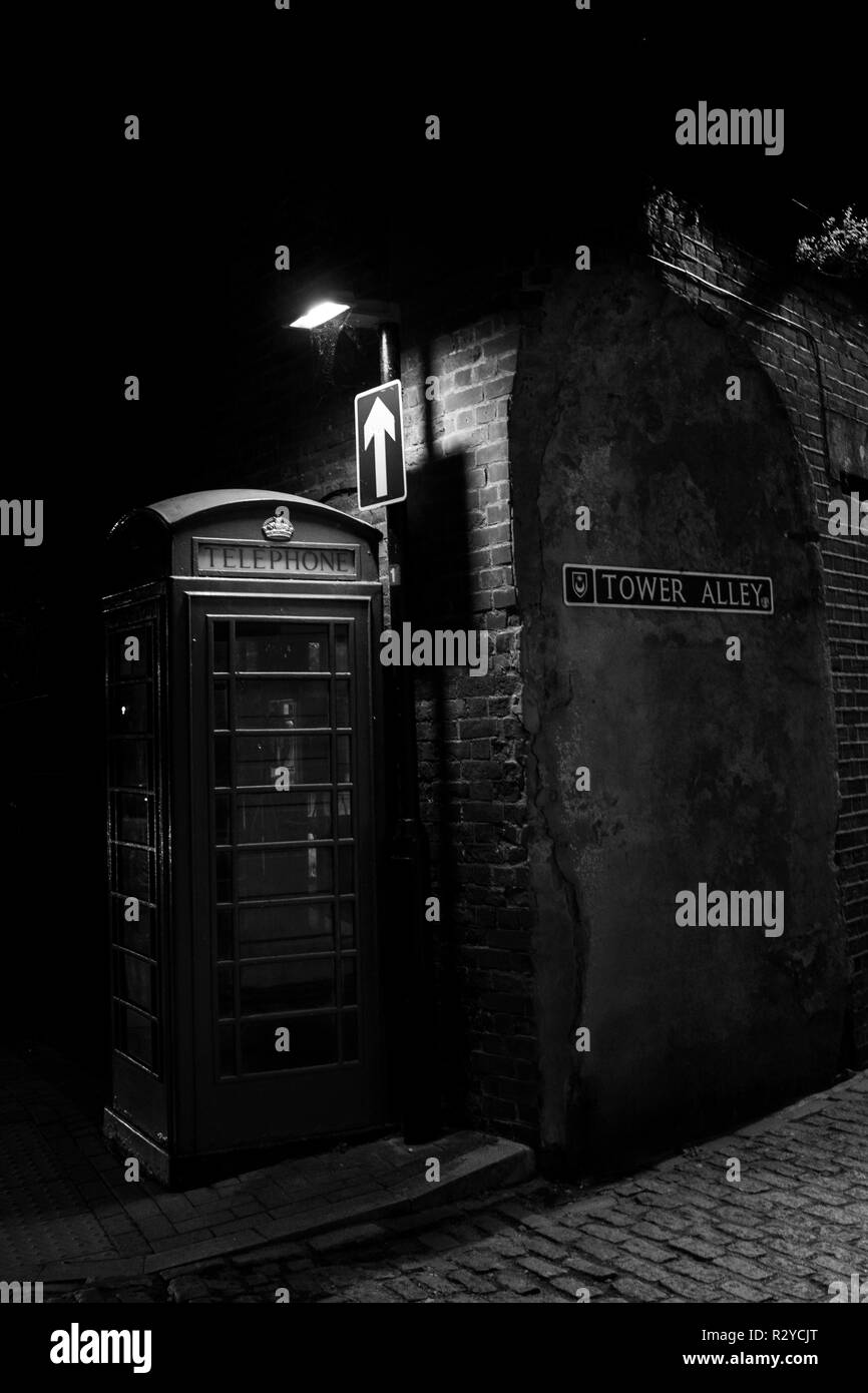 Un vintage British telefono casella sotto via la luce su una strada acciottolata Foto Stock