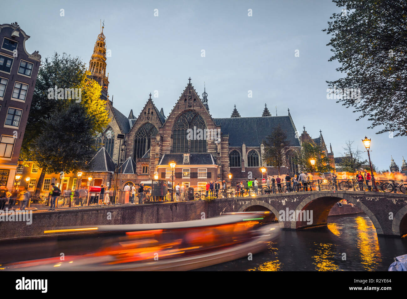 Amsterdam "Oude Kerk" chiesa e il vecchio ponte di sera Foto Stock