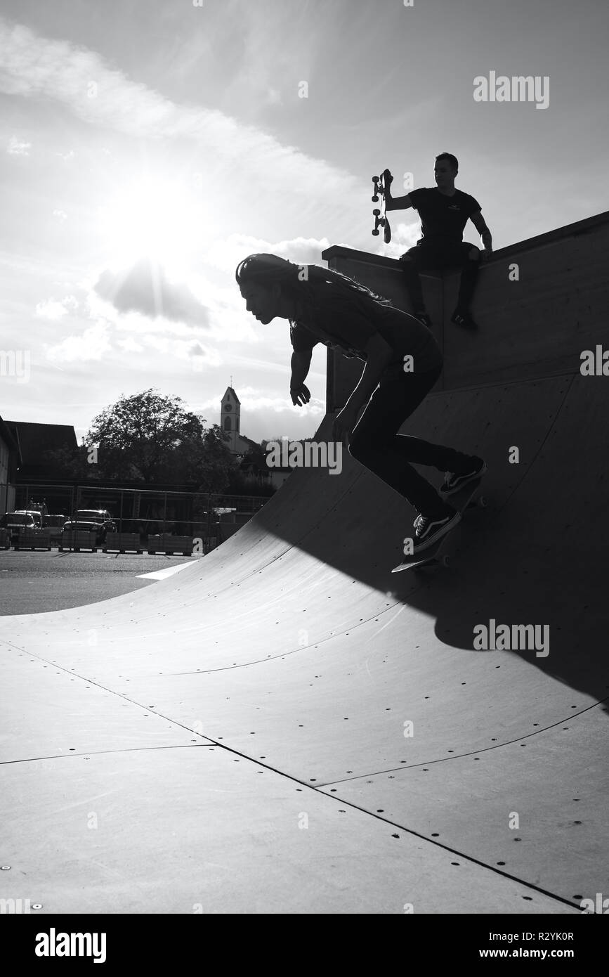 Immagine in bianco e nero di un guidatore di skateboard in un halfpipe Foto Stock