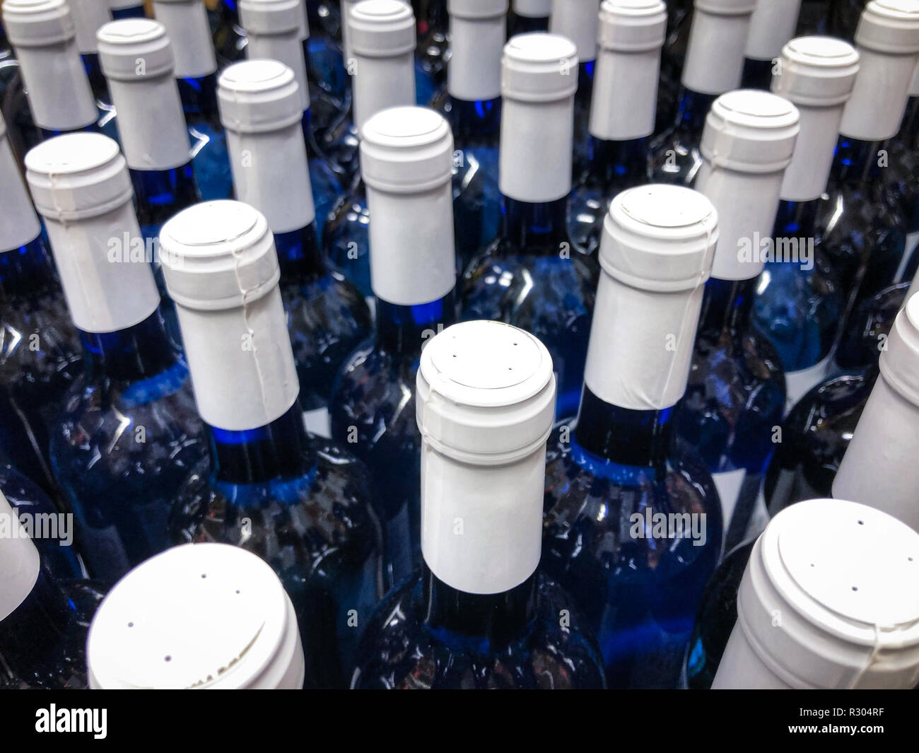 Le bottiglie di vino - molti bottes blu con etichetta bianca / i colli di bottiglia Foto Stock