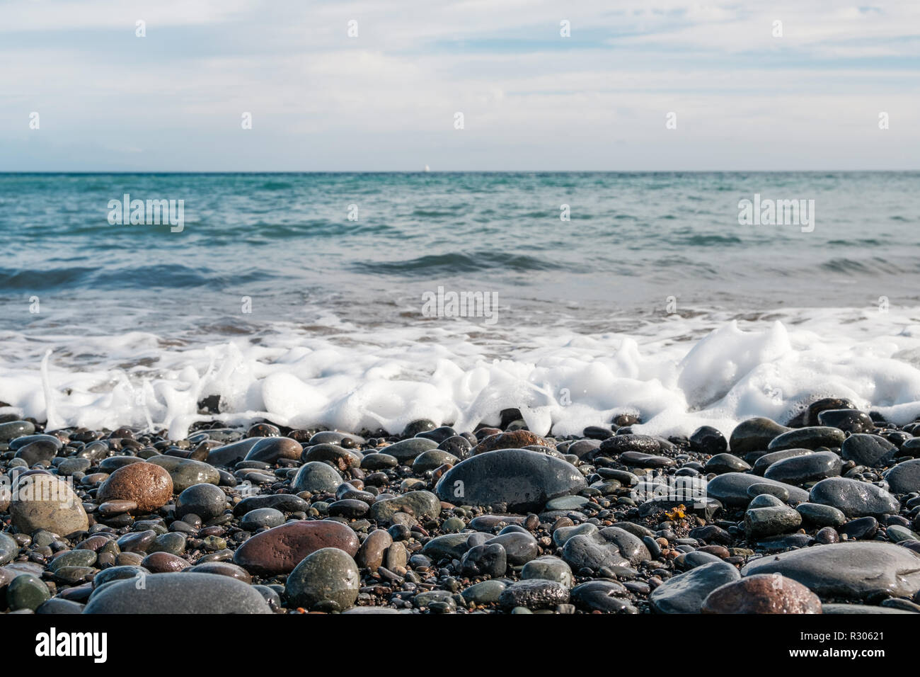 Ghiaiosa spiaggia di pietra - pietre sulla costa dell'oceano Foto Stock