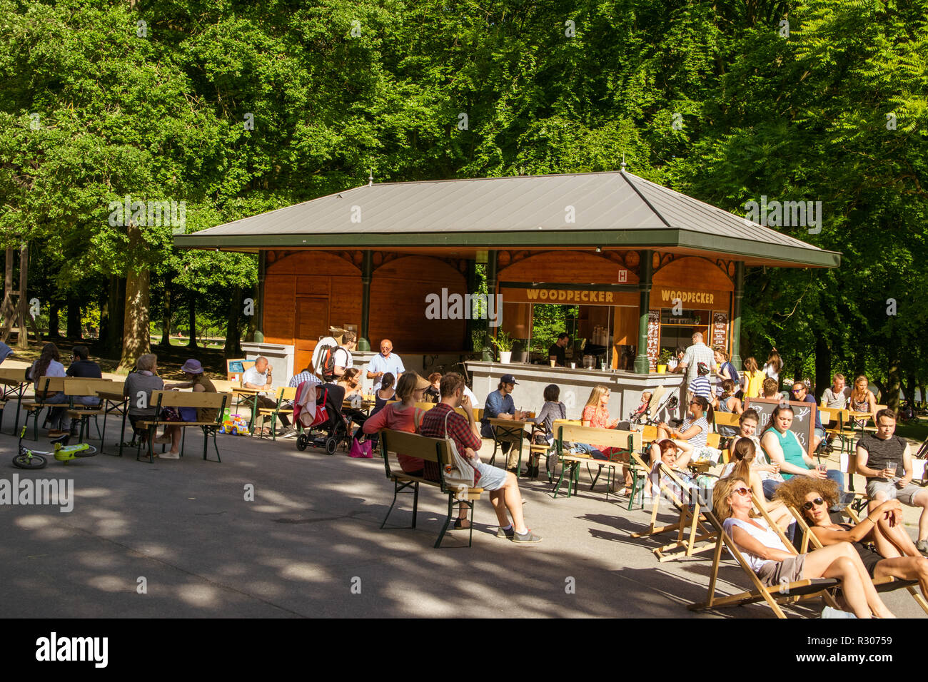 La gente del luogo avente una bevanda fredda e un periodo di riposo nella città parco Bois de la Cambre durante una calda giornata estiva in Ixelles, Bruxelles, Belgio Foto Stock