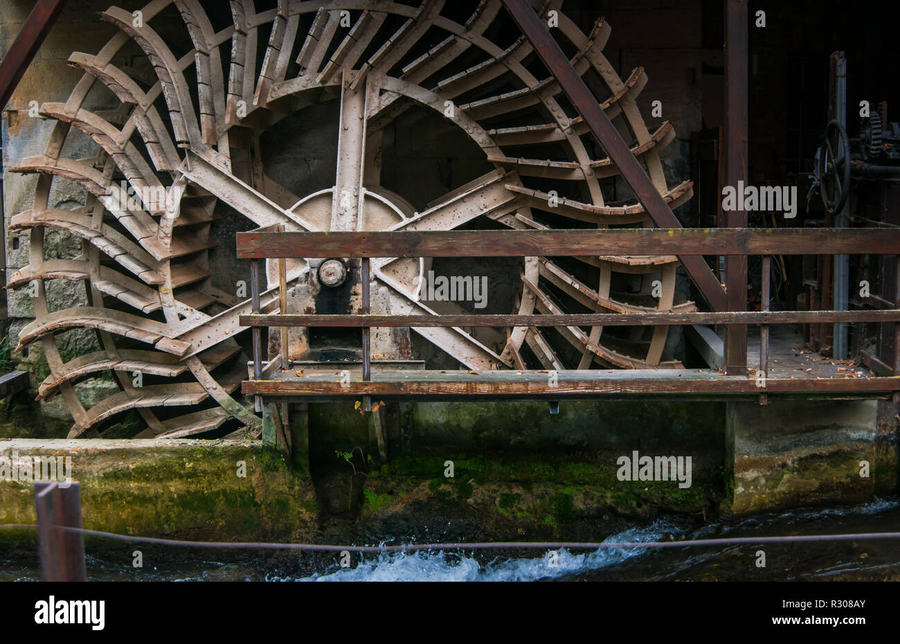 Il vecchio ponte di legno e la ruota di un antico mulino ad acqua Foto Stock