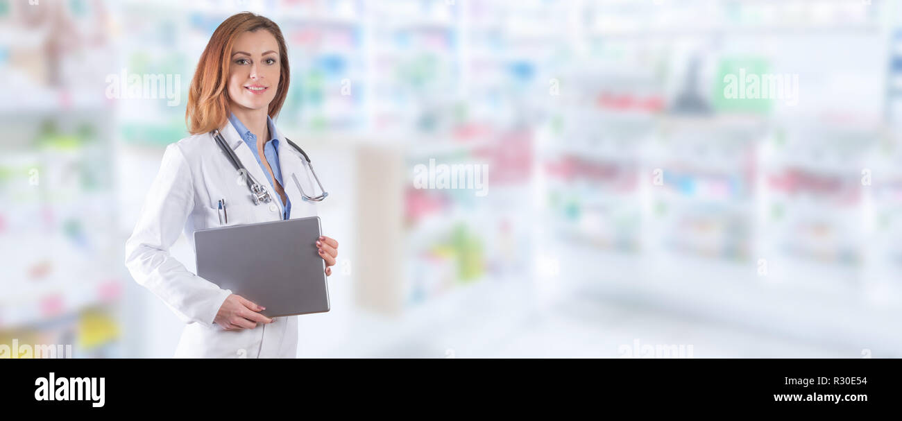 Donna dottore tablet PC o laptop in piedi sopra sfocato farmacia interna. Foto Stock