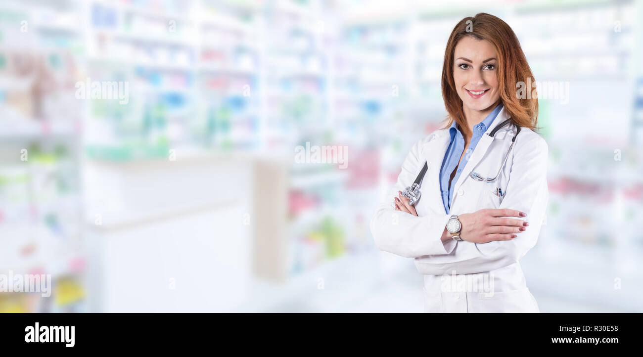 Medico donna in piedi sopra sfocato farmacia interna. Foto Stock