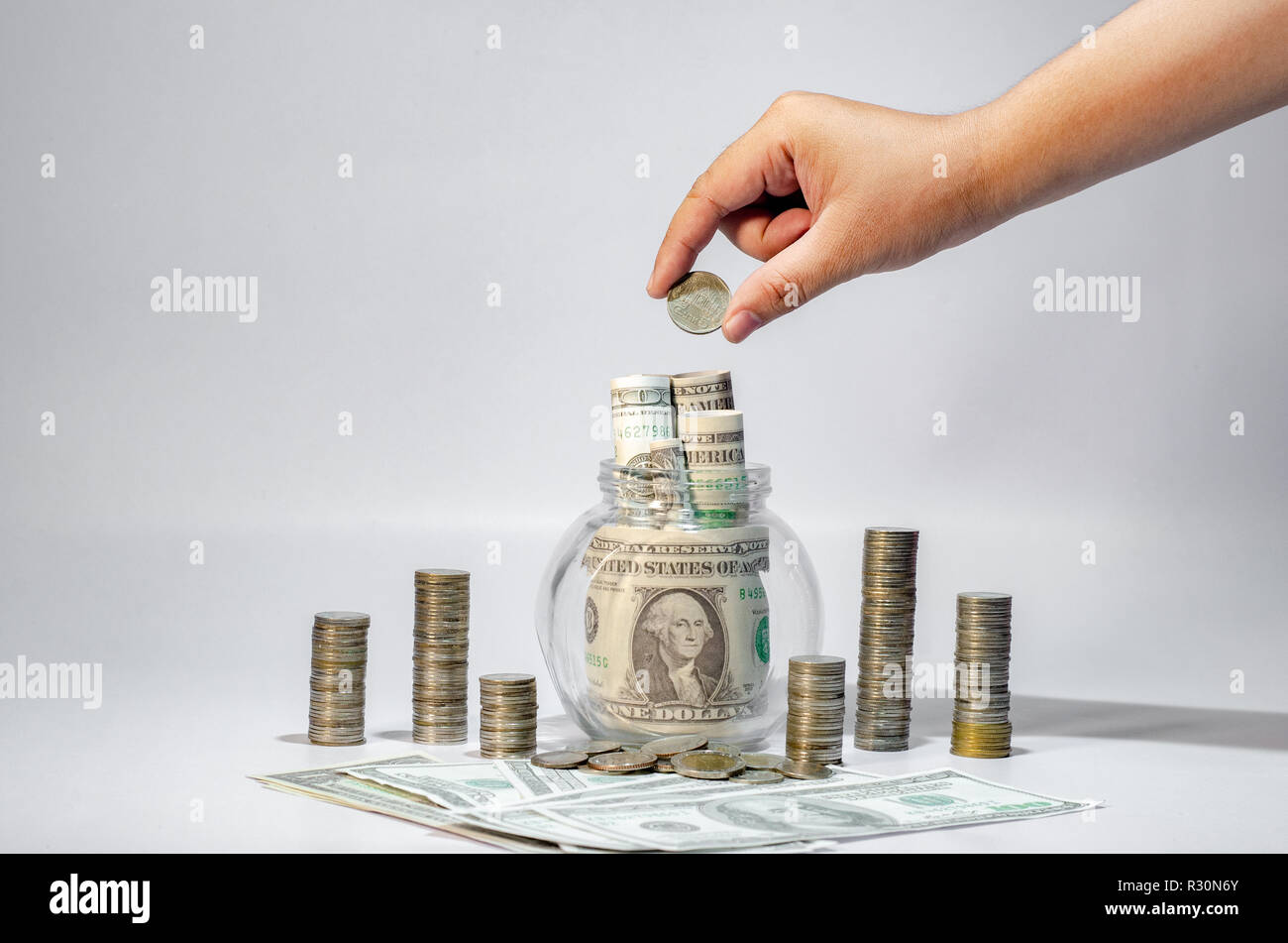Mano la crescita di denaro per un risparmio di denaro. Monete superiore al concetto illustrato ai cambiamenti di un business in espansione Foto Stock
