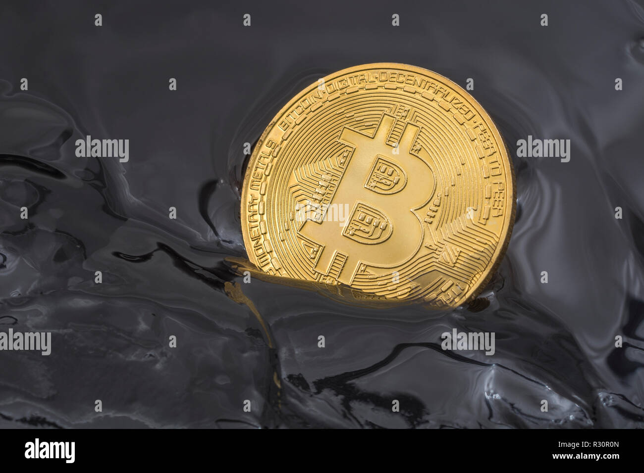 Immagine concettuale di Bitcoin oro affondato in nero morass. Per il crollo del prezzo di Bitcoin 2021, crollo di bitcoin, crollo del mercato della criptovaluta. Foto Stock