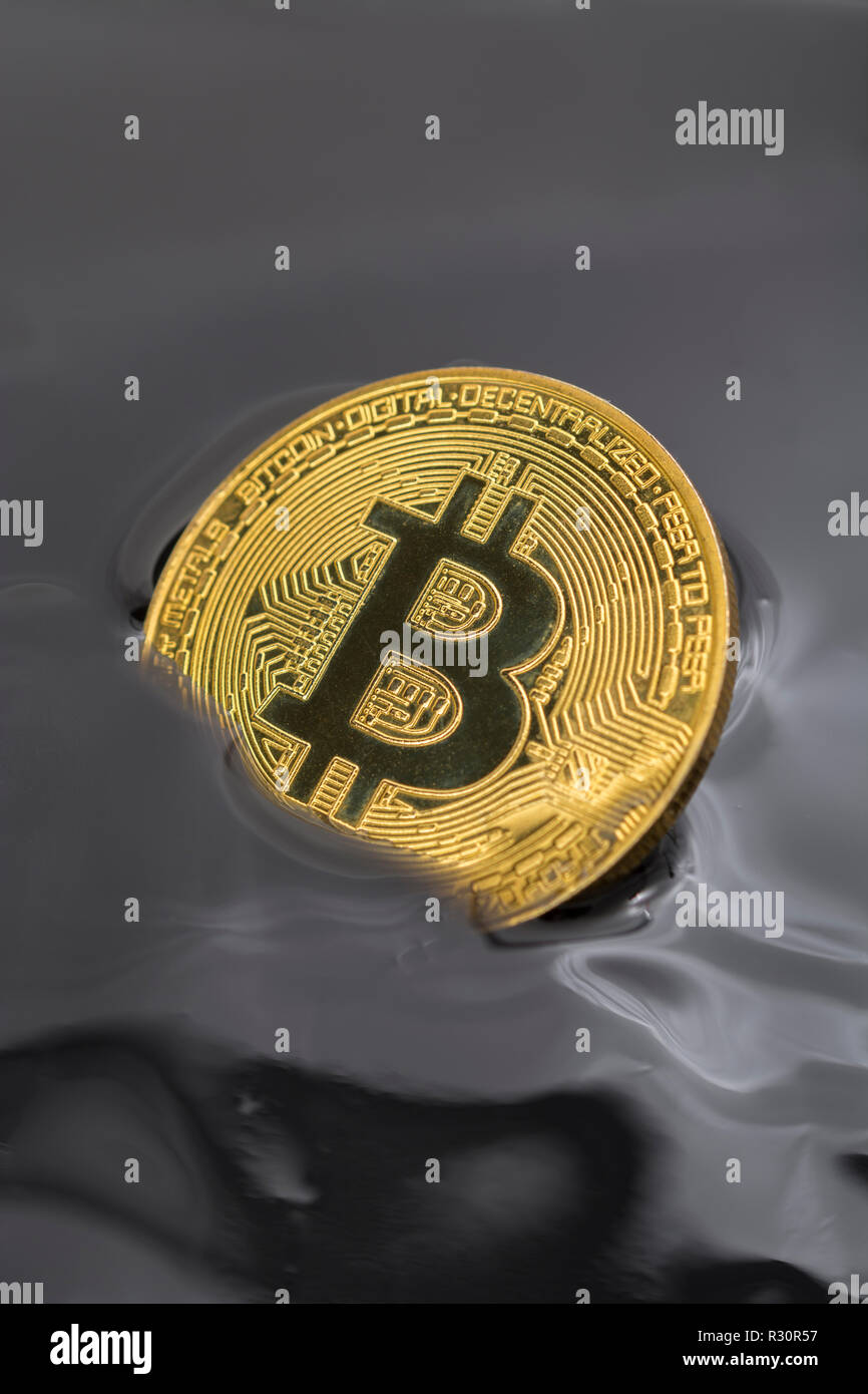 Immagine concettuale di Bitcoin oro affondato in nero morass - per il 2018 Bitcoin price crollo, cryptocurrency mercato crash, 2012 Bitcoin prezzo crash. Foto Stock