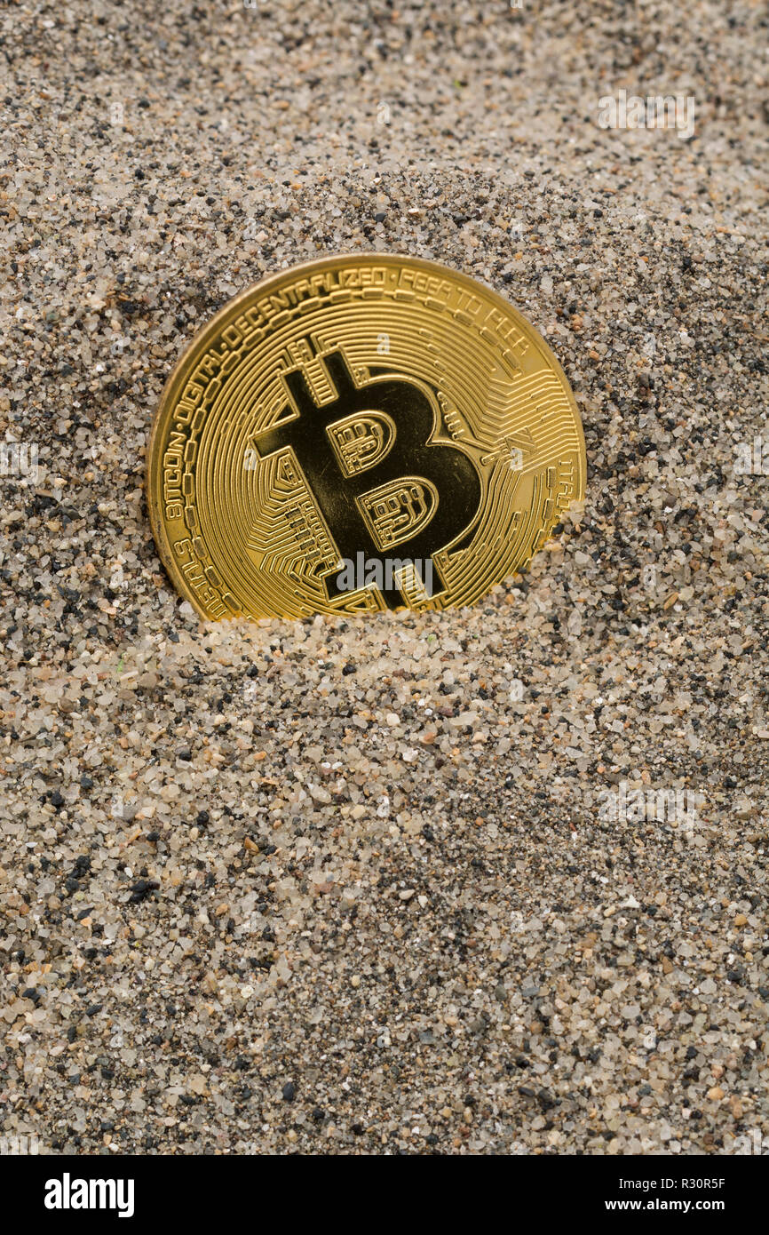 Immagine concettuale di un Bitcoin d'oro affondato nella sabbia - per il crollo del prezzo di Bitcoin 2021, crollo del bitcoin, crollo del mercato della criptovaluta. Foto Stock